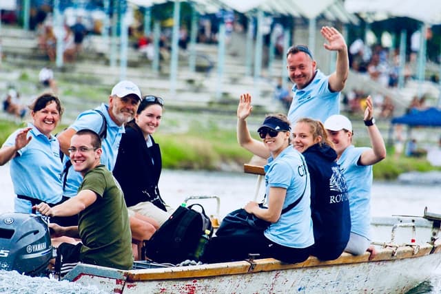 People in a motorboat, greeting the photographer.